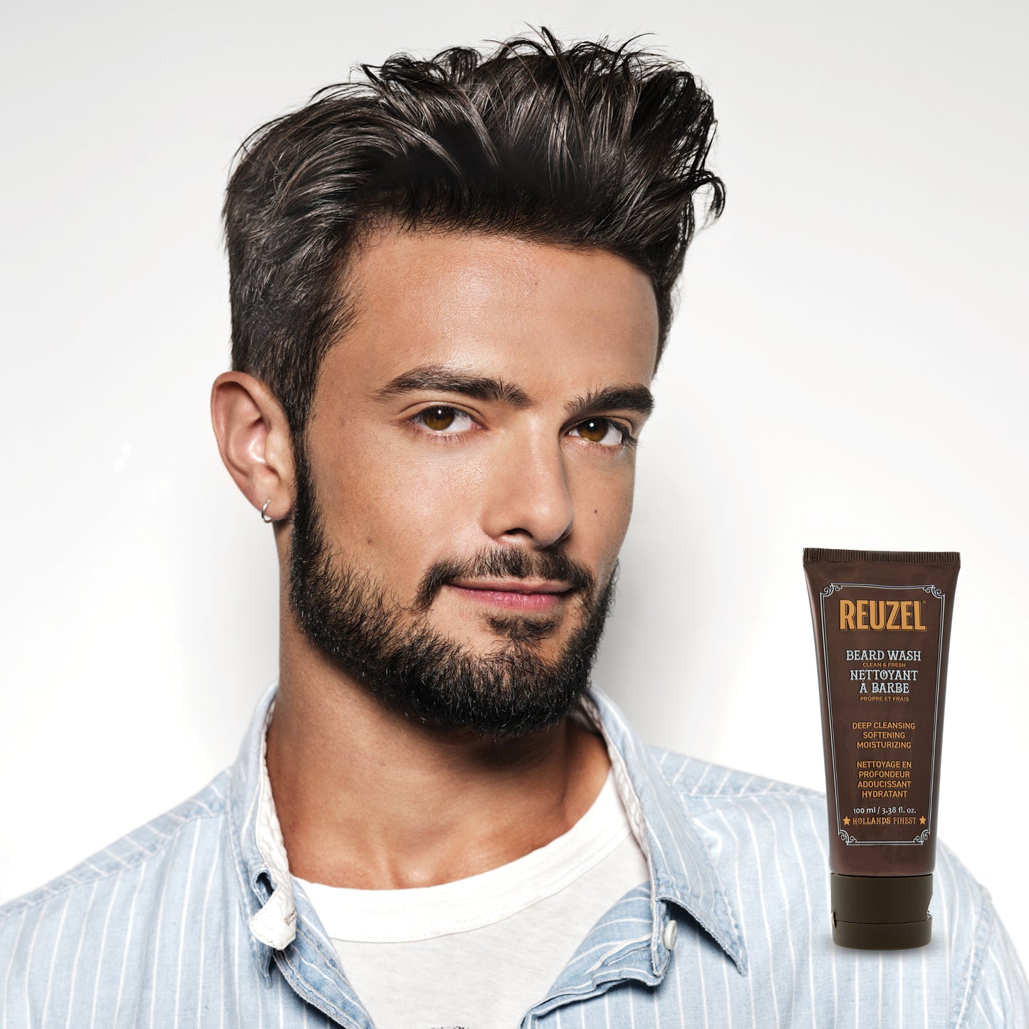 Male model with short black hair and beard next to REUZEL beard wash