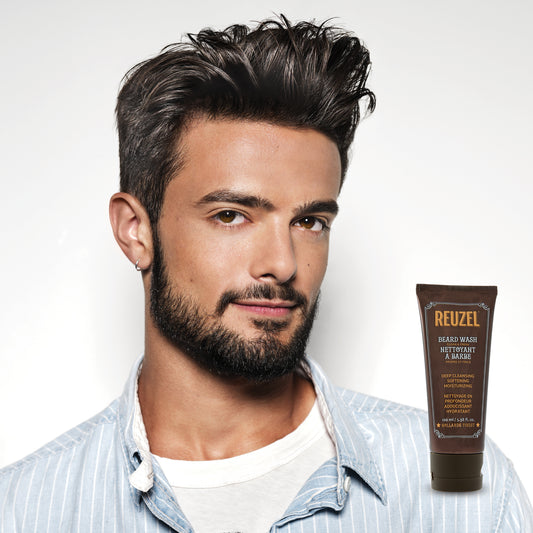 Male model with short black hair and beard next to REUZEL beard wash
