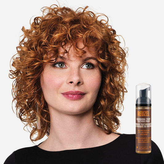 Woman with curly hair next to a bottle of ReuzelGrooming Tonic Texture Foam
